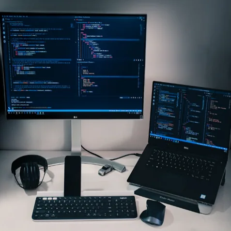 Escritorio con dos monitores mostrando código